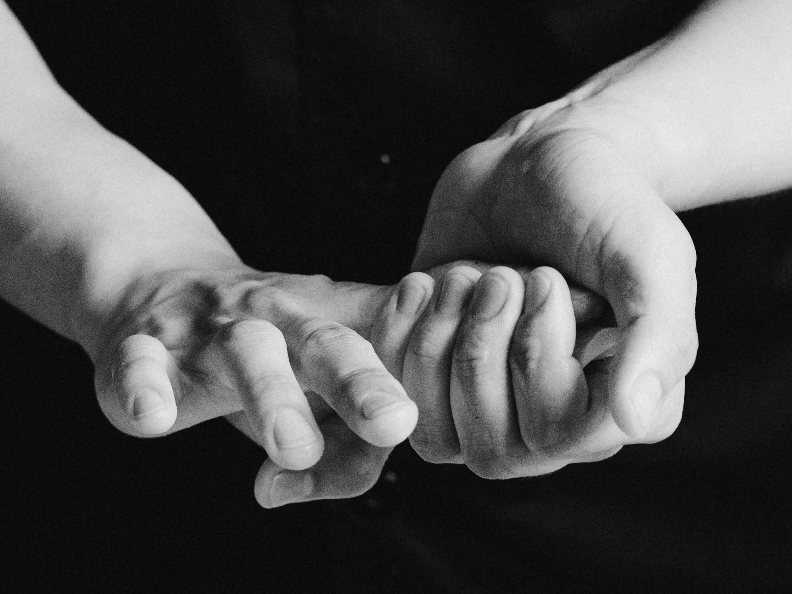 Two hands pressing a piece of nigiri, in black and white